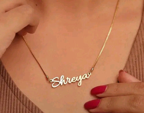 Gold necklace with 'Shreya' pendant on a person's neck